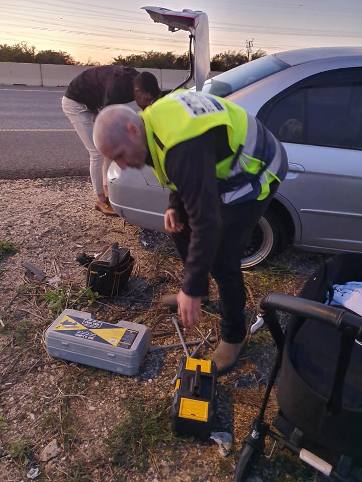 ידידים מסייעים למשפחה בהחלפת הגלגל